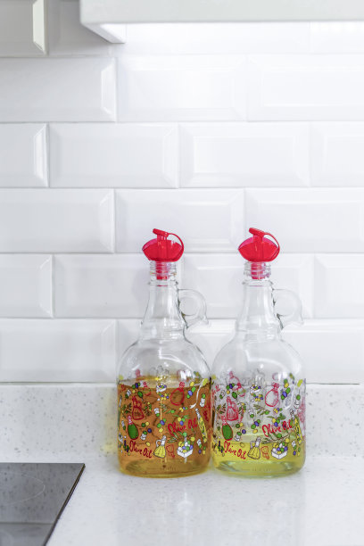 厨房柜台上放着橄榄油瓶，白色陶瓷前面图片下载