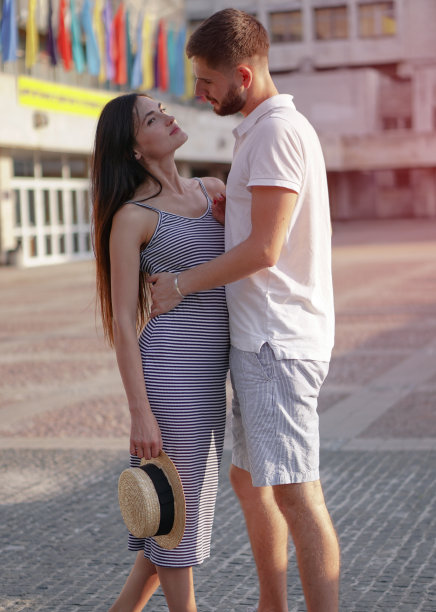 一对美丽的男人和女人在混凝土城市房屋的背景。一个女孩和一个男孩的浪漫主题。春天，夏天照片关系，爱情，情人节图片下载