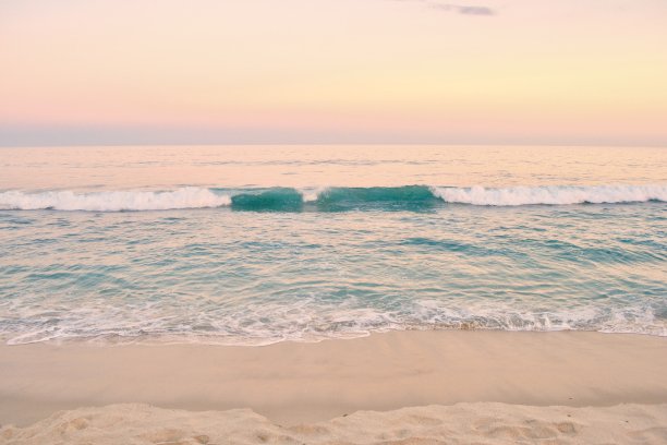 海滩日落与绿松石的波浪图片下载