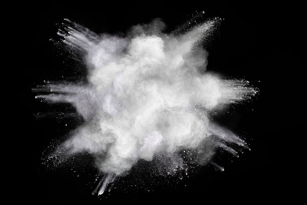 白色粉末在黑暗背景上爆炸的冻结运动。图片下载