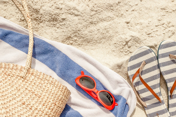草包，太阳镜和人字拖在热带沙滩上。旅游、度假的概念。图片下载