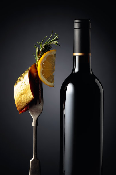 一瓶葡萄酒和烟熏鲭鱼配柠檬片。图片下载