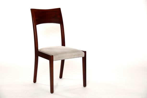 在白色背景下拍摄的带靠垫的木制椅子图片下载