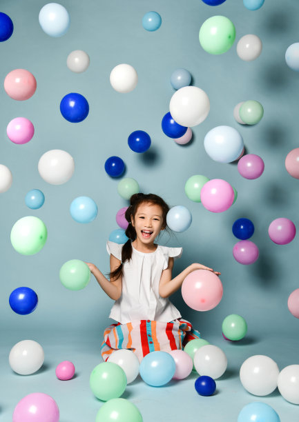 坐在彩色气球中玩耍的时尚条纹长裙亚洲女孩图片下载