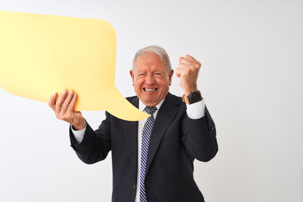 年长的灰发商人拿着语音气泡，在白色背景前恼怒地喊叫图片下载