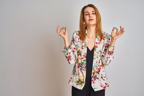 穿着春季花卉外套，冥想的年轻白人女商人图片下载