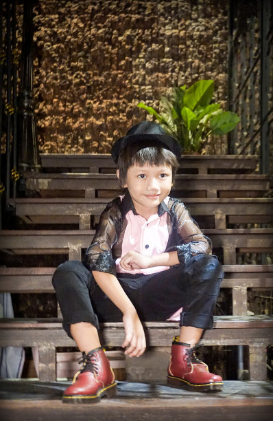 一个印度尼西亚男孩坐在自家门前的台阶上。图片下载