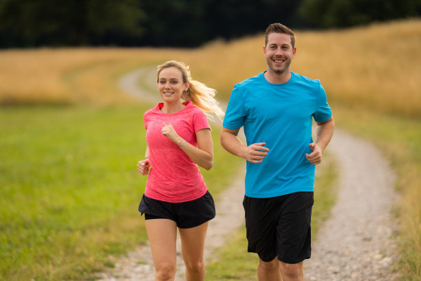 微笑情侣在乡村小路上慢跑图片下载
