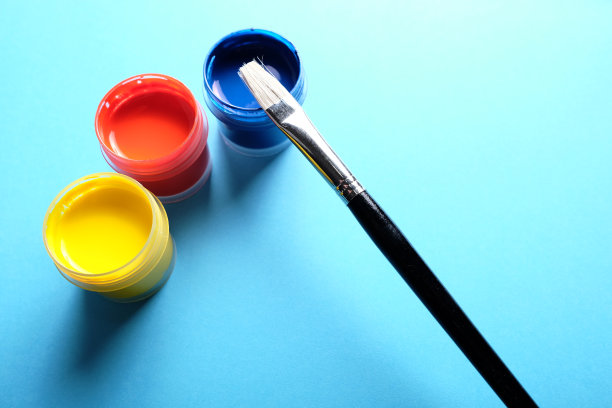 用黑色画笔把塑料容器中的油漆涂成蓝色。图片下载