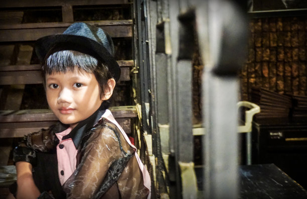 一个印度尼西亚男孩坐在自家门前的台阶上。图片下载