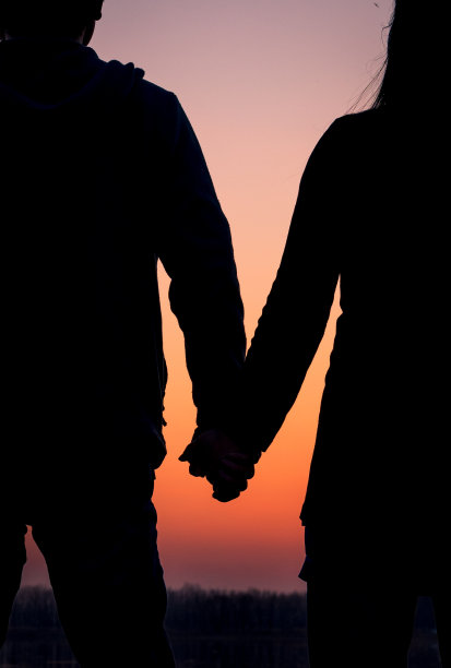 日落时分，这对夫妇在湖边手牵着手图片下载