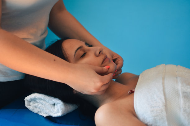 年轻女子享受面部按摩水疗沙龙图片下载