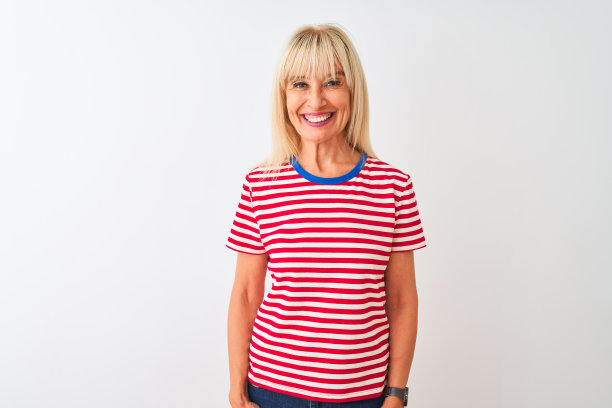 中年妇女穿着休闲条纹T恤站在孤立的白色背景前，脸上带着快乐而酷酷的微笑。幸运的人图片下载