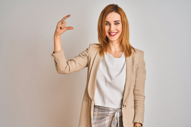 自信的白人女商人站在独立背景前，用手势比划小尺寸图片下载