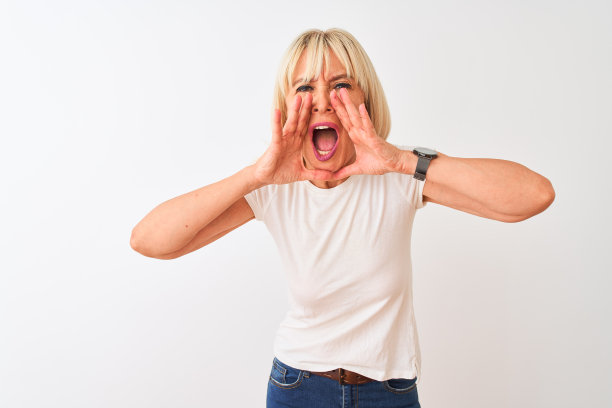 穿着休闲T恤的中年妇女，在白色背景前用手捂住嘴大声喊叫图片下载