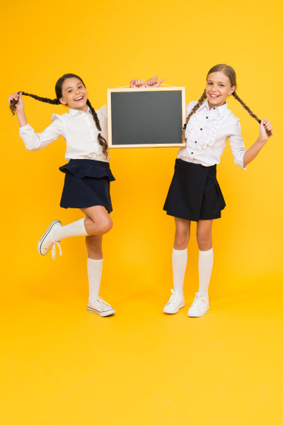 通知更改。学校女生可爱的小学生抱着黑板抄空间。学校通知的概念。同学首创团队黄色背景。加入学校俱乐部。学生社区。学校安排图片下载