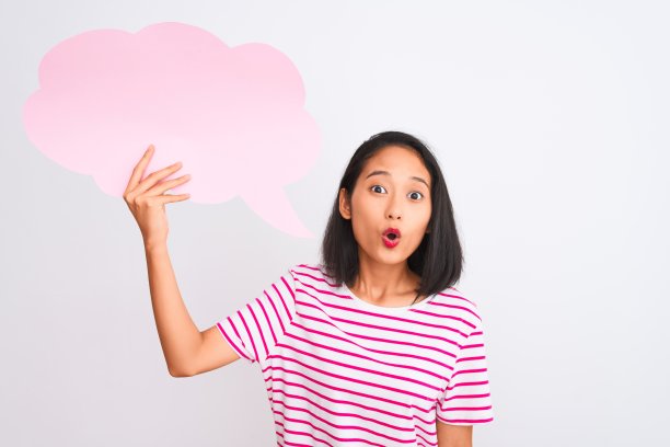 年轻的中国女子抱着云说话泡泡站在孤立的白色背景上吓了一跳，脸上带着惊讶、害怕和兴奋的恐惧表情图片下载