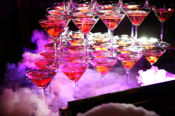 玻璃金字塔的葡萄酒杯，樱桃，紫色的灯光和特殊的烟图片下载