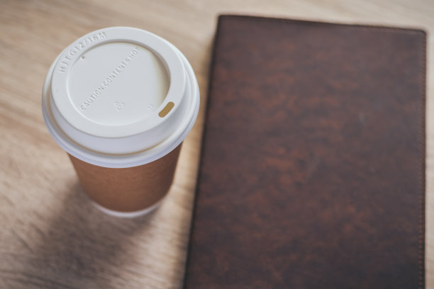 棕色纸杯咖啡与书，教科书或日记，在木桌与复印空间。品牌和标志的照片概念，咖啡厅，休闲，阅读，茶点，放松。餐饮形象图片下载