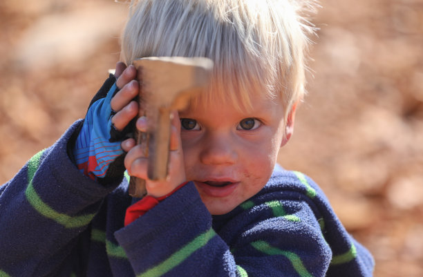 一个小男孩在玩玩具枪图片下载