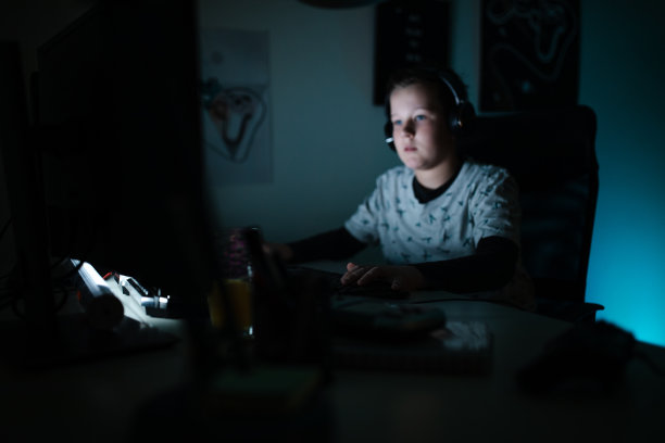 好奇的玩家男孩在深夜玩网络游戏图片下载