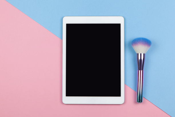 visagiste的现代工作空间，俯视图。平板，化妆刷上双色背景粉、蓝，复制空间，平铺。小型企业，在家工作，使用技术概念。水平图片下载
