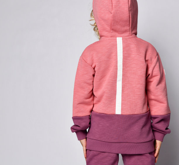 漂亮的卷发金发宝贝女孩孩子在现代时尚粉紫色帽衫摆后面与文本空间图片下载