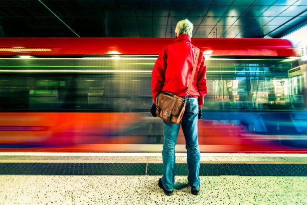 城市人在站台上等待着高速行驶的火车的模糊运动图片下载