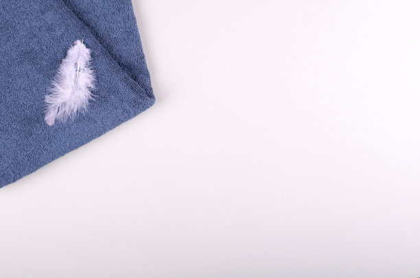 羽毛与毛巾在灰色的背景构成。图片下载