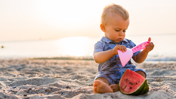 小男孩和西瓜在沙滩上图片下载