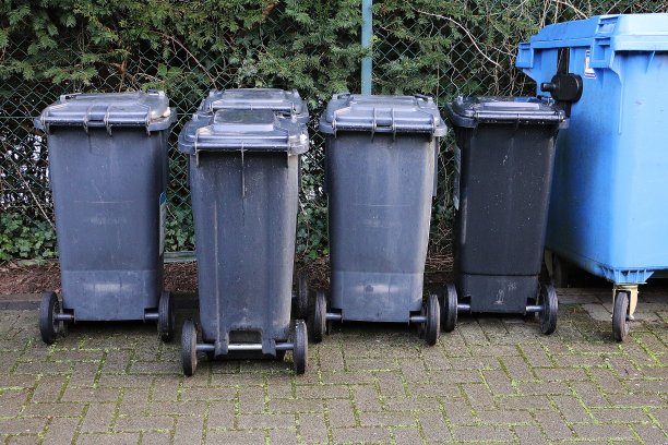 栅栏边有一排黑色的垃圾桶图片下载