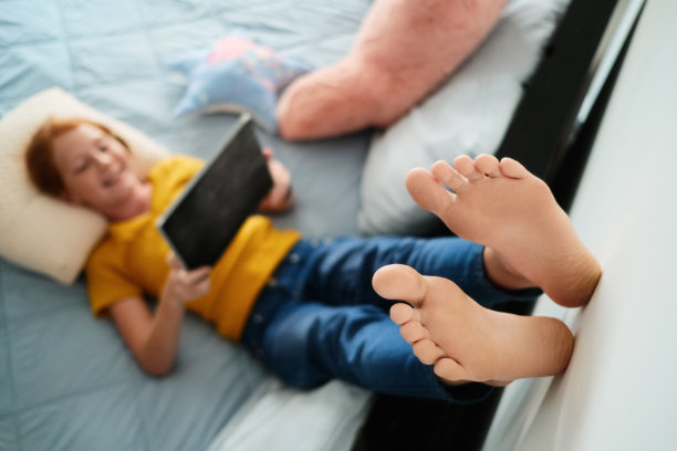 红发女孩在家用平板电脑看动画片图片下载