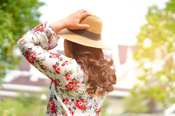 亚洲妇女女士在度假时戴着帽子在公园户外旅行。图片下载