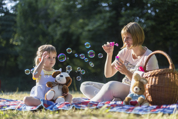 快乐的女人吹肥皂泡度假和她的女儿图片下载