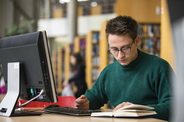 在图书馆学习的年轻成年男学生-库存照片图片下载