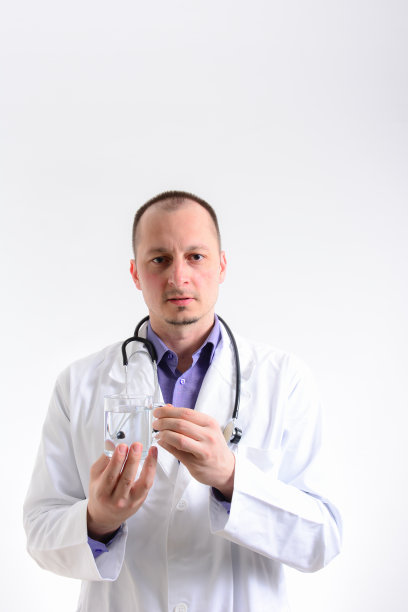 医生拿着一杯清澈的水。治疗师拿着一杯清澈的水。医生建议喝健康的水，空出空间图片下载