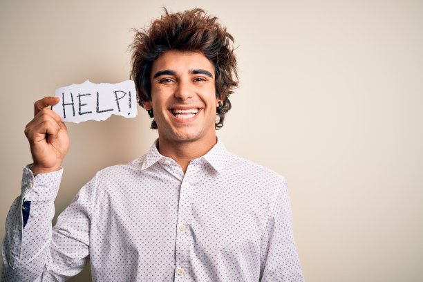 年轻英俊的男子拿着纸与帮助信息在孤立的白色背景与一个快乐的脸站着，微笑与自信的微笑显示牙齿图片下载
