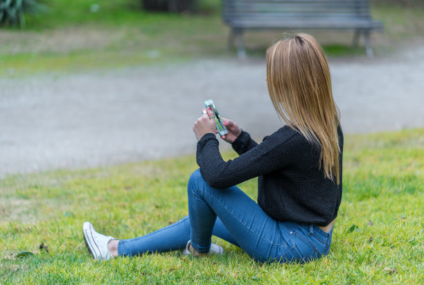 在公园里看手机的女人图片下载