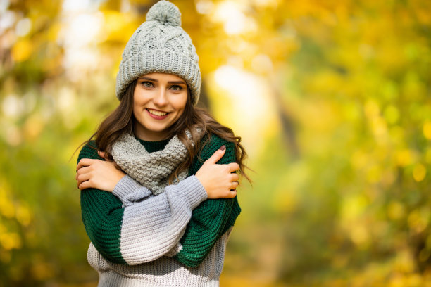 秋日公园里戴着帽子和围巾的快乐女孩照片图片下载