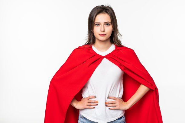 年轻女子身穿英雄外套，在白色背景前图片下载