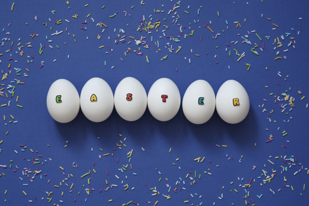 创意设计的白色鸡蛋与铭文复活节由彩色字母在蓝色背景。图片下载