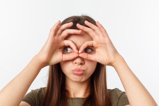 快乐，可爱，时尚，有吸引力，时髦的女孩做双筒望远镜的手指，孤立在灰色背景，有好心情图片下载