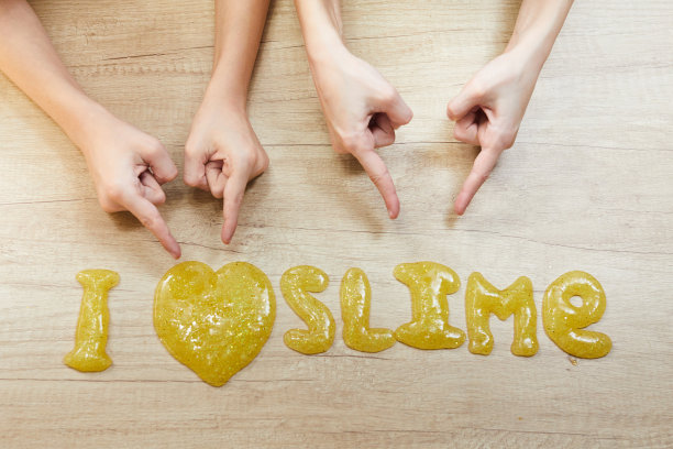 我爱在桌上微笑。孩子们玩黏液。自制的流行玩具黏液。创造性的孩子图片下载