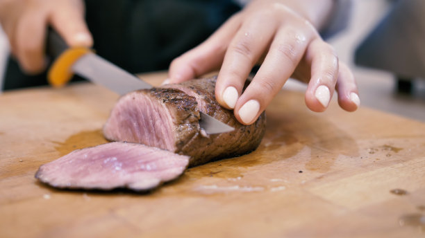 女厨师把肉排切成薄片图片下载