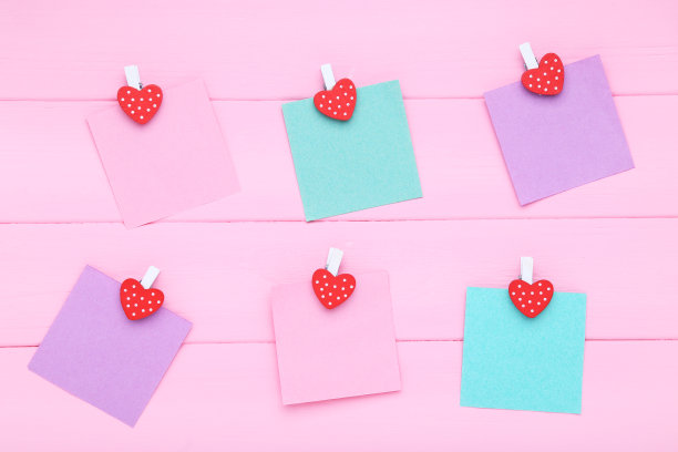 粉红色的木桌上放着贴有晾衣夹的便利贴图片下载