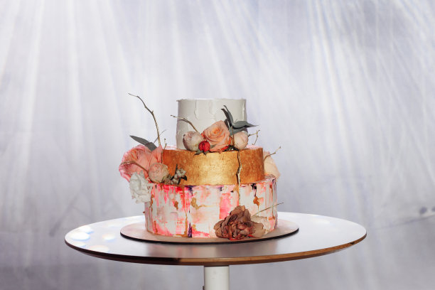 三层蛋糕和鲜花庆祝。图片下载