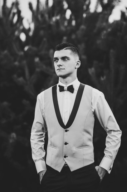 严肃的肖像英俊的新郎西装和领结。人类站在森林里。自然,国家。黑白照片。图片下载