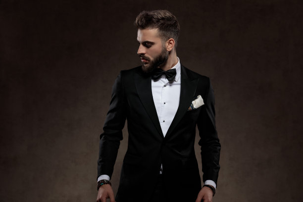 忧郁的时尚新郎穿着西装时看向别处图片下载