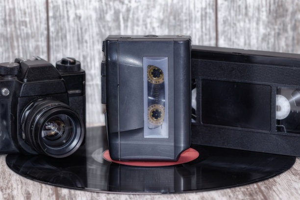 木质背景的盒式录音机、摄影机和VHS盒式磁带图片下载