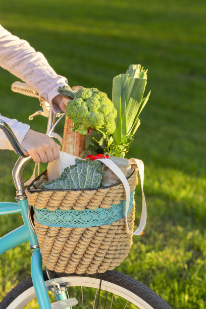 近距离的女性收集素食产品到篮子上的复古自行车图片下载